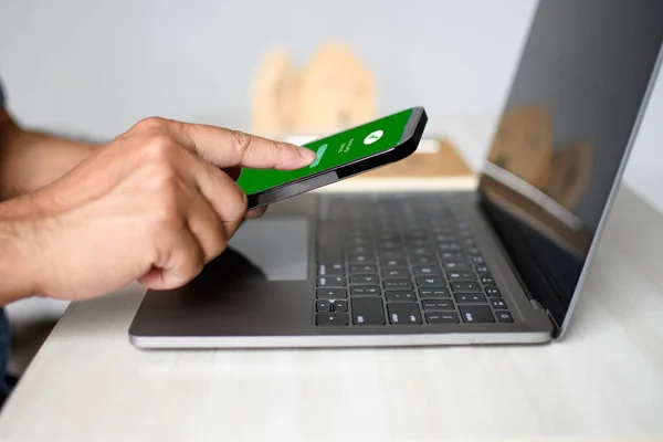 Bir adamın eli ekranda akıllı telefonu tutar para gönderilir ve bir tuşa basılır. Mobil cihazlarla yapılan finansal işlemler kavramı. Para, transfer, telefon, kopyalama alanı. Beyaz arka grup