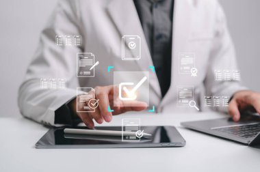 Bir işadamı ileri teknoloji kullanarak dijital belgeleri verimli bir şekilde yönetir ve onaylar. Bu resim modernleştirilmiş süreçleri, geliştirilmiş üretkenliği ve modern bir ortamda stratejik uyumu tasvir eder.