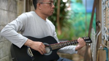 Odaklanmış Besteciler Açık Hava Performansı Siyah Akustik Gitar Gri Gömlekliler Vücut Rahatlığı ve İş Düzenleme İçin