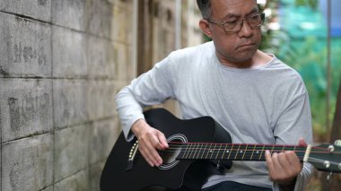 Asya Mans Ciddi İfade Gri Akustik Gitar Çalıyor Dışarıdaki Sokak Arkasındaki Gri Duvara Karşı