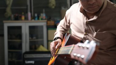 Akustik Gitar virtüözü Kahverengi Düğme Gömleği Aşağı Odaklanmış El Kapalı Salon Işığı Rahatlamak İçin