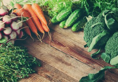 Bahar hasat - rustik ahşap zemin üzerine taze sebze grubu. Tonlu görüntü