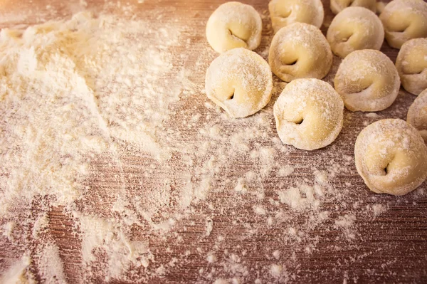 Top view on homemade pasta ravioli over wooden table with flour — Stock Photo, Image