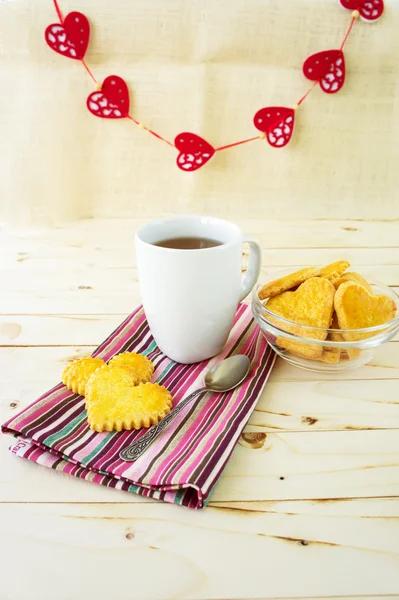 Gebak Cookies in de vorm van harten met kopje thee — Stockfoto