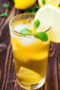 Ahşap masa üzerinde limon ile buzlu çay bardak