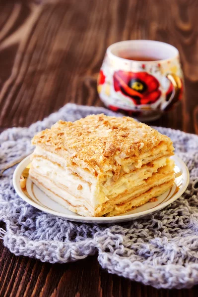Millefeuille pastry with a cup of tea on wooden table — Stock Photo, Image