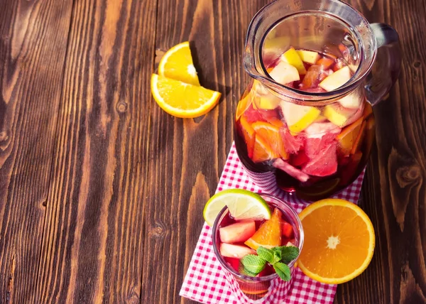 Una jarra de sangría refrescante con frutas sobre fondo de madera —  Fotos de Stock