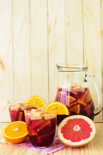 A jug of refreshing sangria with fruits on wooden background — Stock Photo, Image