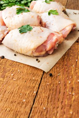 Maydanoz boşaltmak ile ahşap masa üzerinde çiğ tavuk uyluk