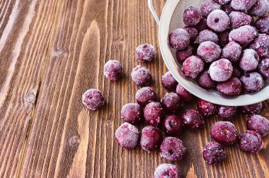 Ahşap arka plan, seçici odak üzerinde dondurulmuş vişne çilek