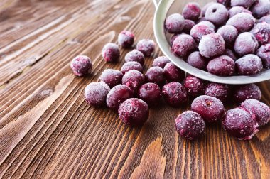 Ahşap arka plan, seçici odak üzerinde dondurulmuş vişne çilek