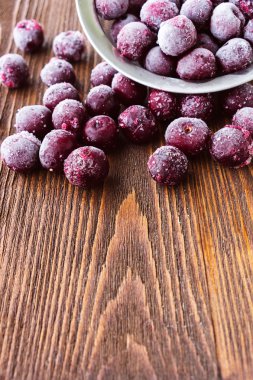 Ahşap arka plan, seçici odak üzerinde dondurulmuş vişne çilek