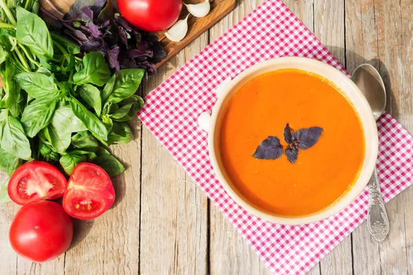 Taze domates fesleğen ve ahşap masa üzerinde domates çorbası