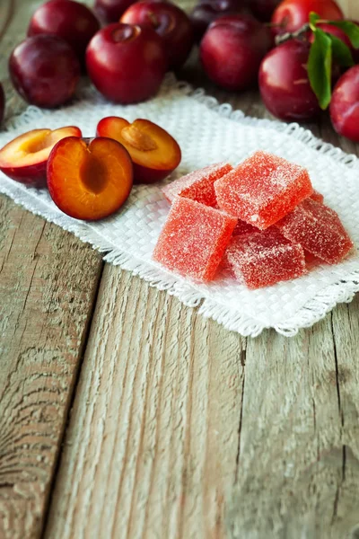 Homemade plum jelly and plums on wood table — Stock Photo, Image