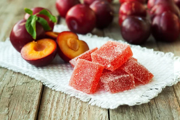 Homemade plum jelly and plums on wood table — Stock Photo, Image