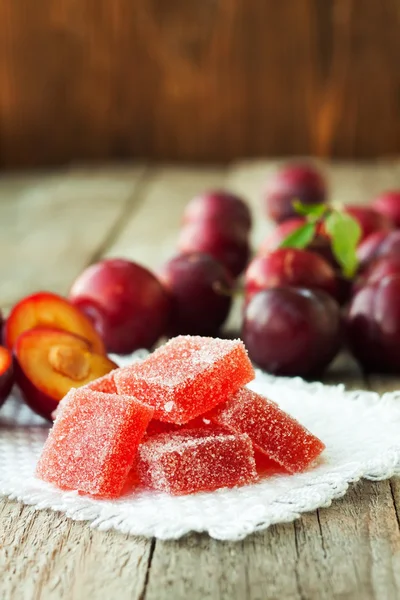 Homemade plum jelly and plums on wood table — Stock Photo, Image