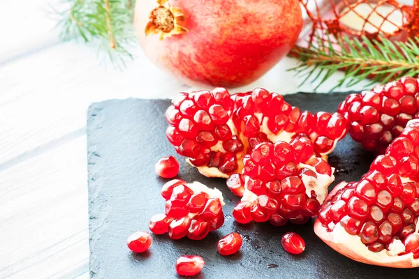 Ripe pomegranate on stone plate — Stock Photo, Image