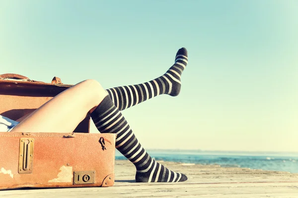 旅行者の女性に移動彼女の足を彼女のスーツケースで座っています。 — ストック写真