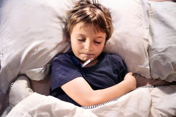 Enfant malade au lit dormir et tester la fièvre — Photo