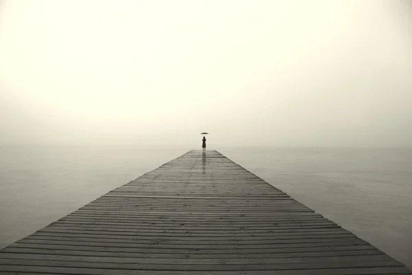 Woman with black umbrella looking infinity in a surreal place — Stock Photo, Image