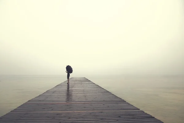 Frau mit Regenschirm blickt friedlich aufs Meer — Stockfoto