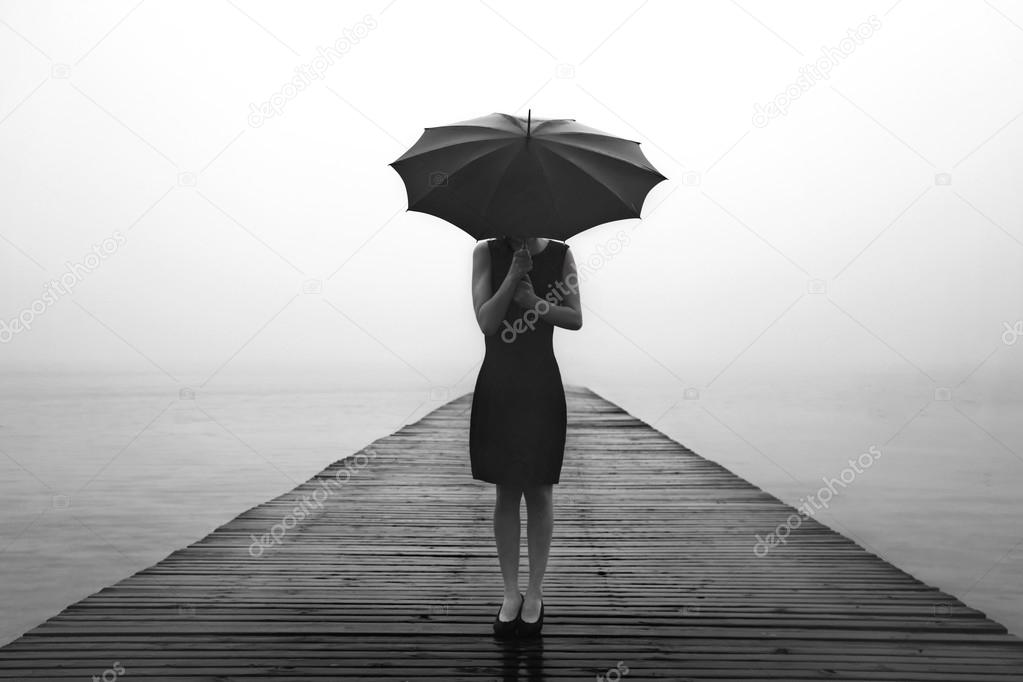 woman with black umbrella looking infinity in a surreal place