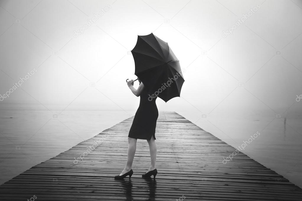 woman with black umbrella looking infinity in a surreal place