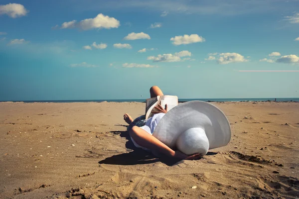 Entspannte Frau liest ein Buch vor dem Meer — Stockfoto