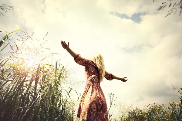 Joven mujer disfrutando de la naturaleza en medio de un prado — Foto de Stock