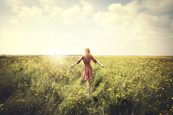 Dreamy woman walking in nature towards the sun — Stock Photo, Image