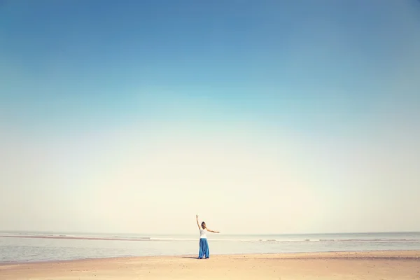 Kvinnan gör meditation övningar mot havet — Stockfoto