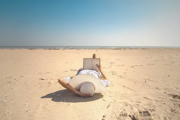 Entspannte Frau liest ein Buch vor dem Meer — Stockfoto