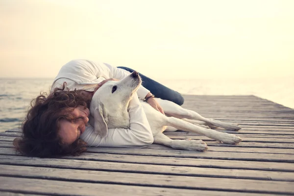 Mujer protectora abrazando a su perro mientras duerme — Foto de Stock