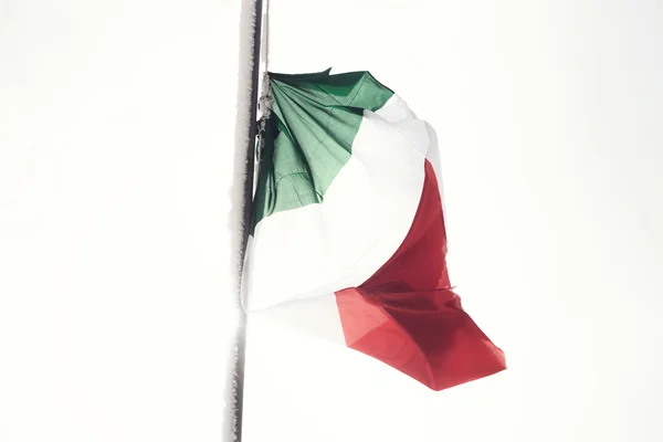 Italienska flaggan fladdrar i ett vitt landskap och snowy — Stockfoto