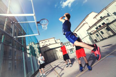 kentsel bir yerde enerji ile oynayan genç basketbolcular