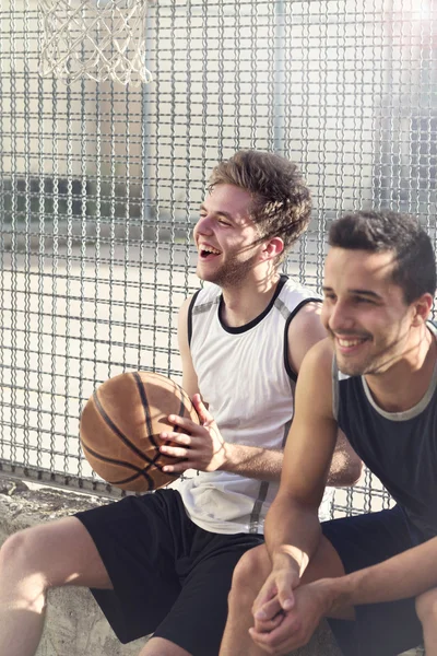 Jugadores de baloncesto descansan sentados en un lugar urbano —  Fotos de Stock