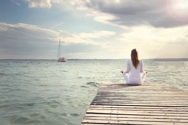 Femme Méditation sur la plage au coucher du soleil — Photo