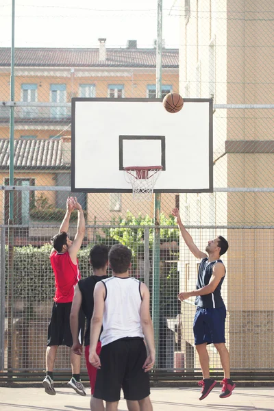 Jeunes joueurs de basket-ball jouant avec énergie dans un lieu urbain — Photo