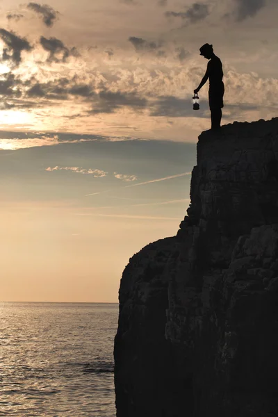 Mystisk pojke med lampan lyser upp vägen till klippan — Stockfoto