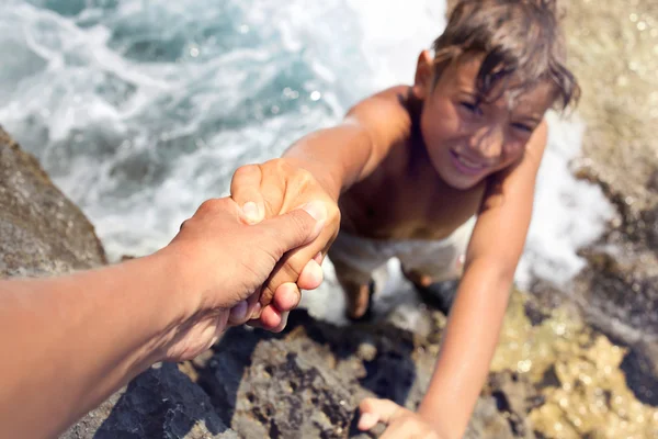 Jongen geholpen door een vriend te beklimmen een ontoegankelijke klif — Stockfoto