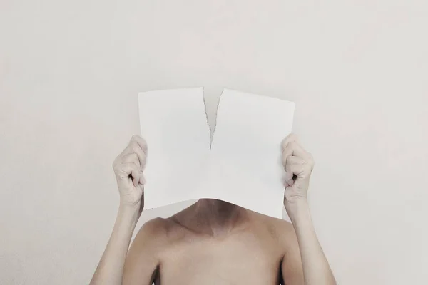 woman with a torn sheet in front of her face, identity crisis