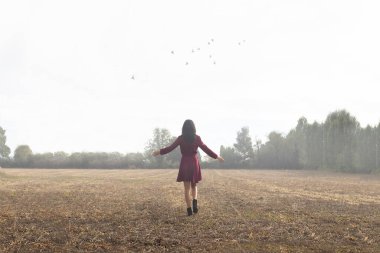 Çayırda özgürce koşan bir kadın