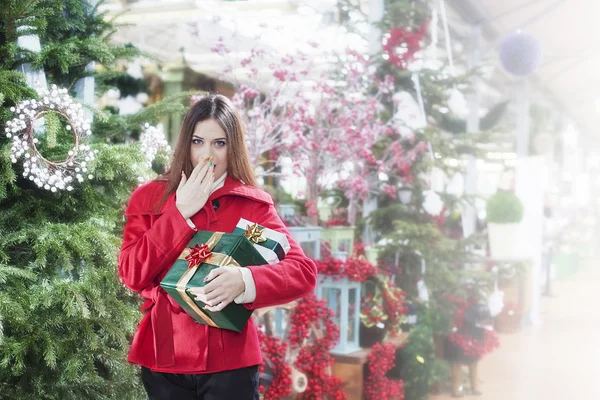 Mujer joven hace un gesto de sorpresa para los regalos de Navidad —  Fotos de Stock
