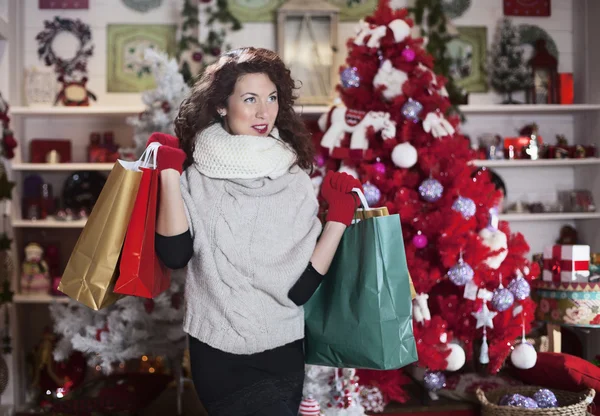 Счастливая девушка думает о своих покупках на Рождество — стоковое фото