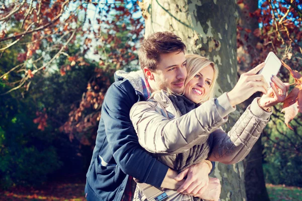 Casal tomando selfie no outono — Fotografia de Stock