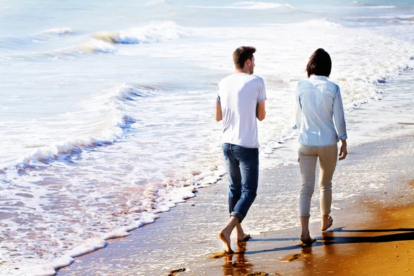 Rückansicht eines Paares, das am Strand spaziert — Stockfoto