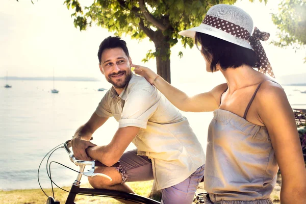 Pareja divirtiéndose en bicicleta de vacaciones al lago — Foto de Stock