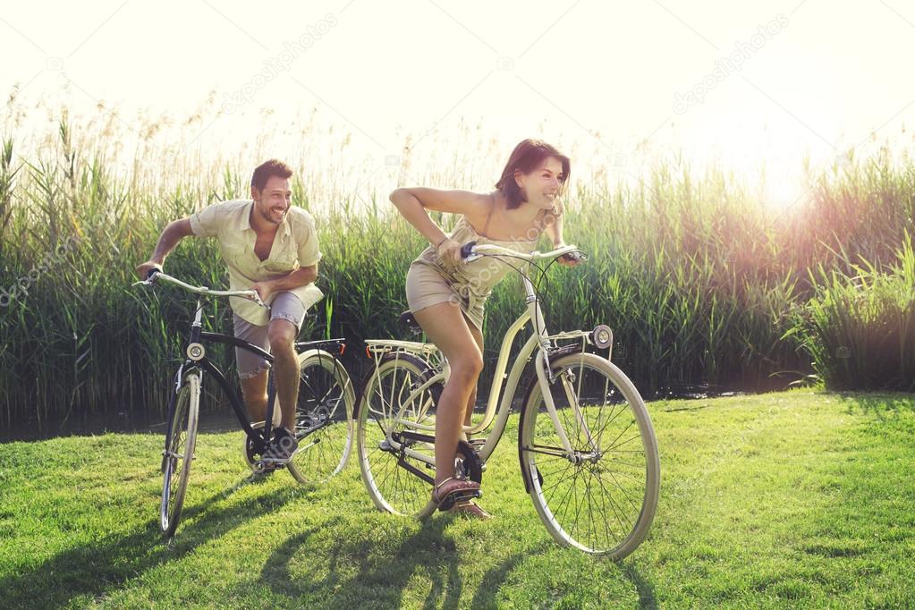 Couple having a bicycles race into the nature