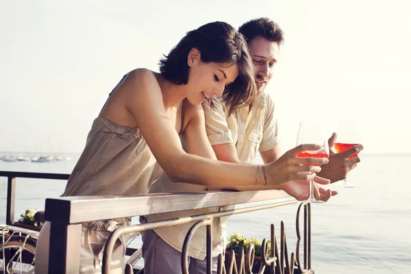 Casal conversando enquanto tem spritz em um terraço vista lago — Fotografia de Stock