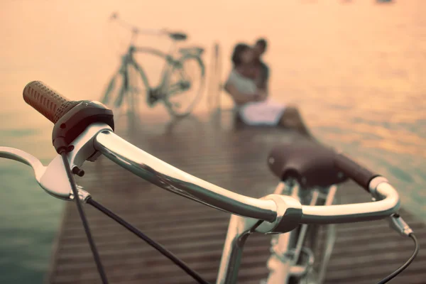 Fahrrad im Vordergrund und im Hintergrund verliebtes Paar — Stockfoto